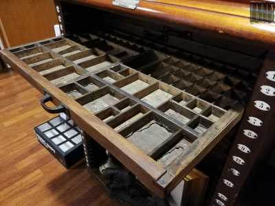 E tra contenitori d�inchiostro, tagliacarte in argento, allungamatite in legno e cassettiere con caratteri mobili per la stampa...